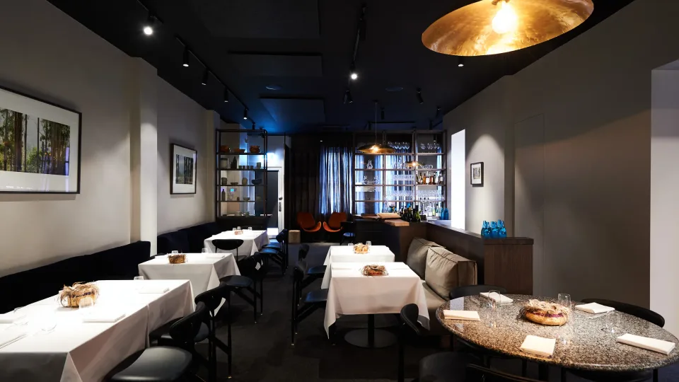 White-clothed tables in the dining room at Attica
